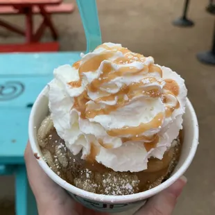 a hand holding a cup of ice cream