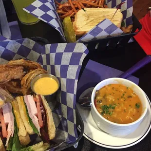 Tower club sandwich with fantastic onion rings, also the other dish with yummy sweet potato fries, and he soup of the day.