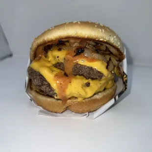 a hamburger with cheese and onions