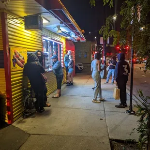 a group of people standing outside of a restaurant