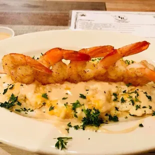 shrimp skewers on a bed of mashed potatoes