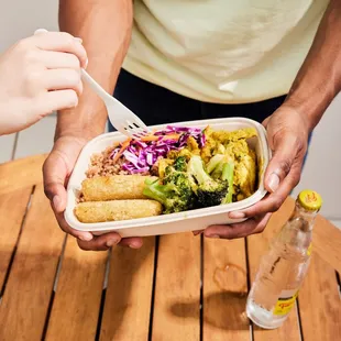 a person holding a container of food