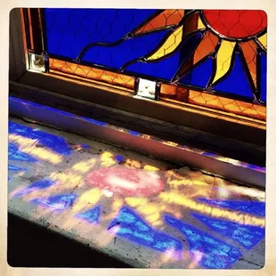 Stained Glass sun panel showing it's shadow.