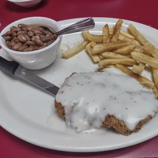 Chicken fried steak and 2 sides, fries and pinto beans.