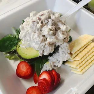 a plate of food with strawberries, cucumber, and crackers