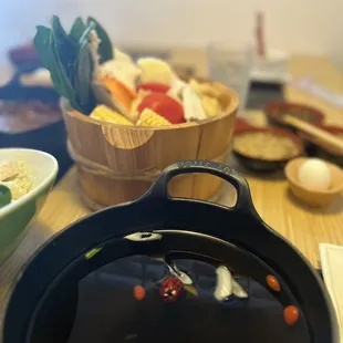 a pot of hotpots and a bowl of vegetables