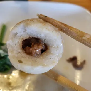 chopsticks holding a piece of food