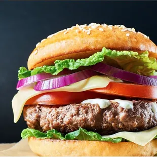 a hamburger with lettuce, tomato, onion, and cheese