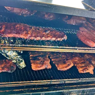 ribs and hot dogs cooking on the grill