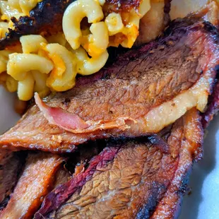 a plate of barbecued meat and macaroni and cheese