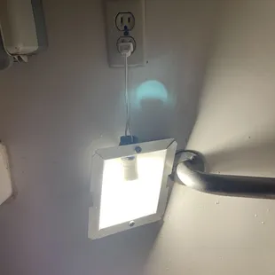 Restroom light next to bathroom sink. Looks dangerous to me!