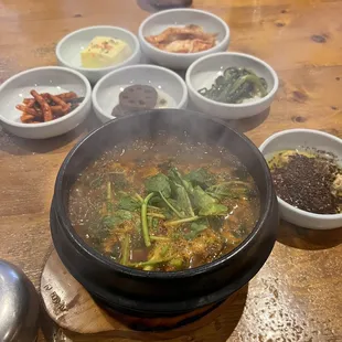 a hot pot of soup on a wooden table