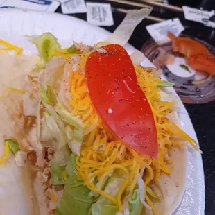 a taco with cheese and lettuce