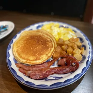 Brunch dish with pancakes, bacon, and eggs