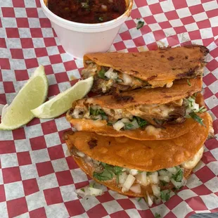 Mouthwatering juicy quesabirrias!! Served with limes and beef consomé broth. The perfect dipping combination!!