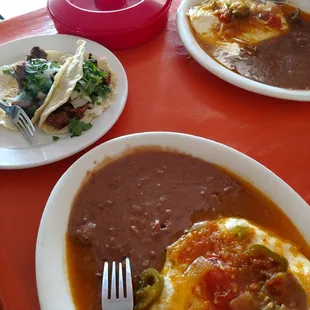 Huevos Rancheros with beans and tortillas. 2 goat tacos and 1 steak taco.
