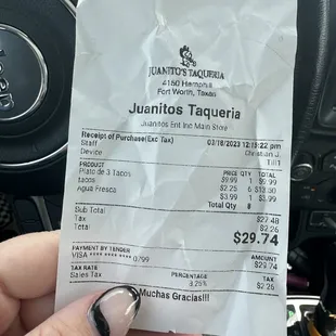 a hand holding a receipt