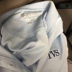 a blue polo shirt with the name of the club