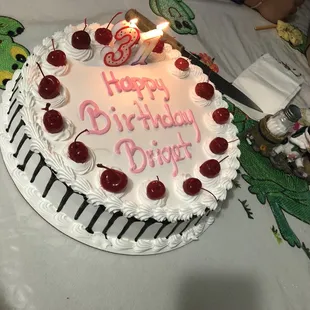 a birthday cake with cherries on it