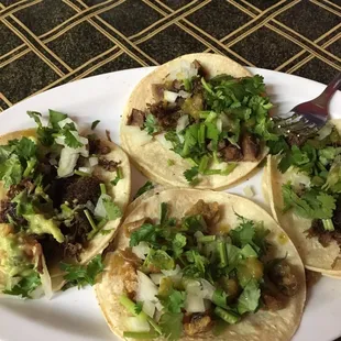 three tacos on a white plate