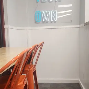 orange chairs and a neon sign