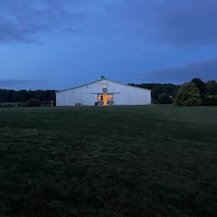 a white barn with a yellow door