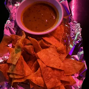 a bowl of salsa and tortillas