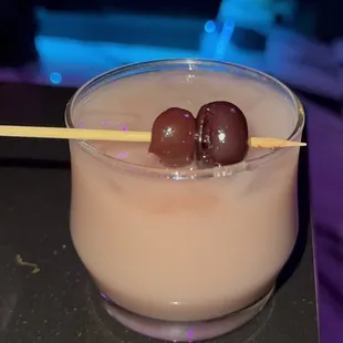 a drink with two olives in it