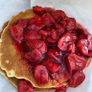 a stack of pancakes topped with strawberries