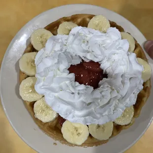 a waffle topped with whipped cream and bananas