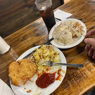 Pork chop, hash browns, eggs and biscuits.