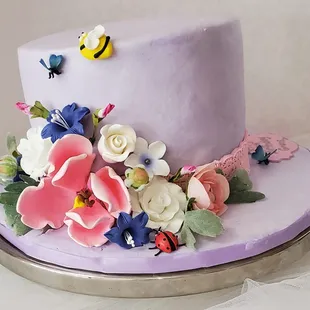a cake decorated with flowers and a bee