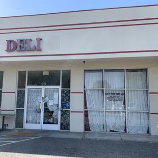 a woman walking in front of a deli