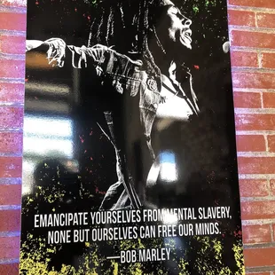 a poster of bob marley on a brick wall
