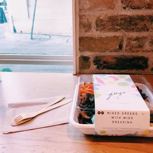 a container of noodles and chopsticks on a table