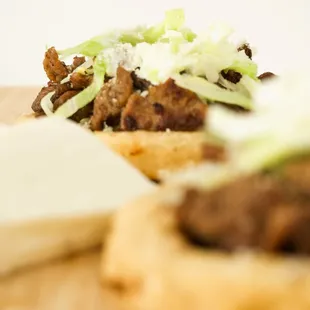a beef sandwich with cheese and lettuce