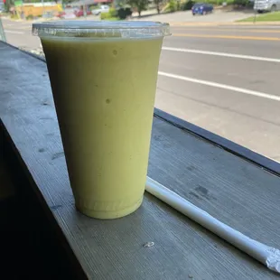 a green smoothie with a straw and a toothbrush