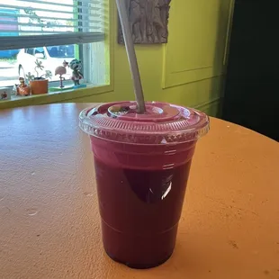 a smoothie in a plastic cup with a straw