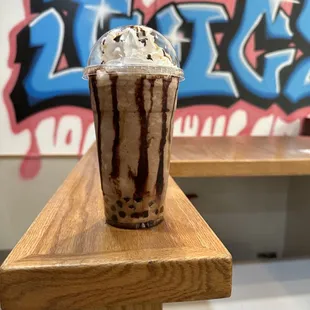 a chocolate milkshake with whipped cream and chocolate sprinkles