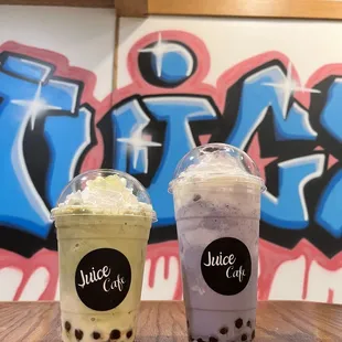 two drinks on a table in front of a graffiti wall