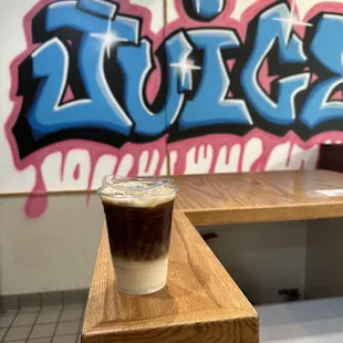 a glass of iced coffee on a wooden table