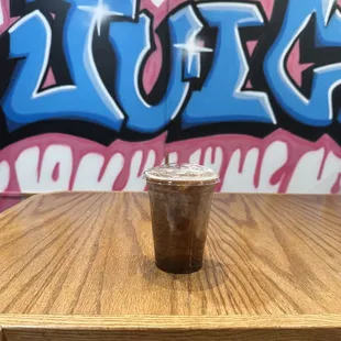 a cup of iced coffee on a wooden table