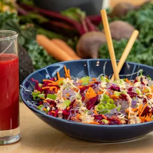 a bowl of salad and a glass of juice