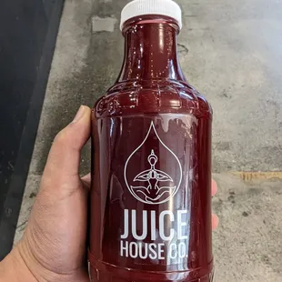 a hand holding a bottle of juice