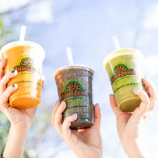 three people holding up their drinks