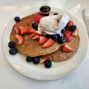 a plate of pancakes with ice cream and strawberries