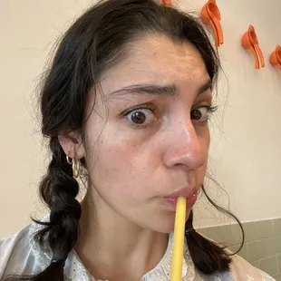 a woman with a straw in her mouth