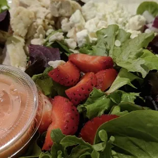 a salad with strawberries and chicken