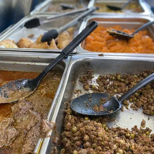 a variety of food being served at a buffet