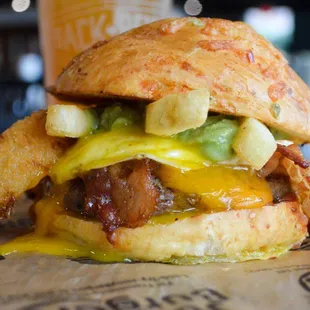 a burger with cheese and onion rings